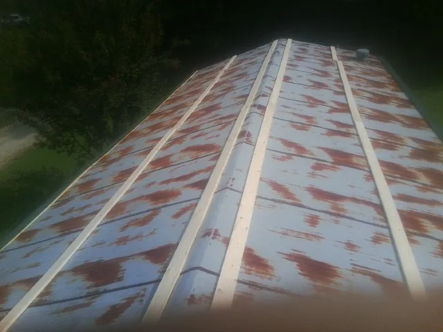 Rusted metal roof panels with new wood purlins before replacement — Storm Damage Roof Repair in Calera by Roofing Brothers