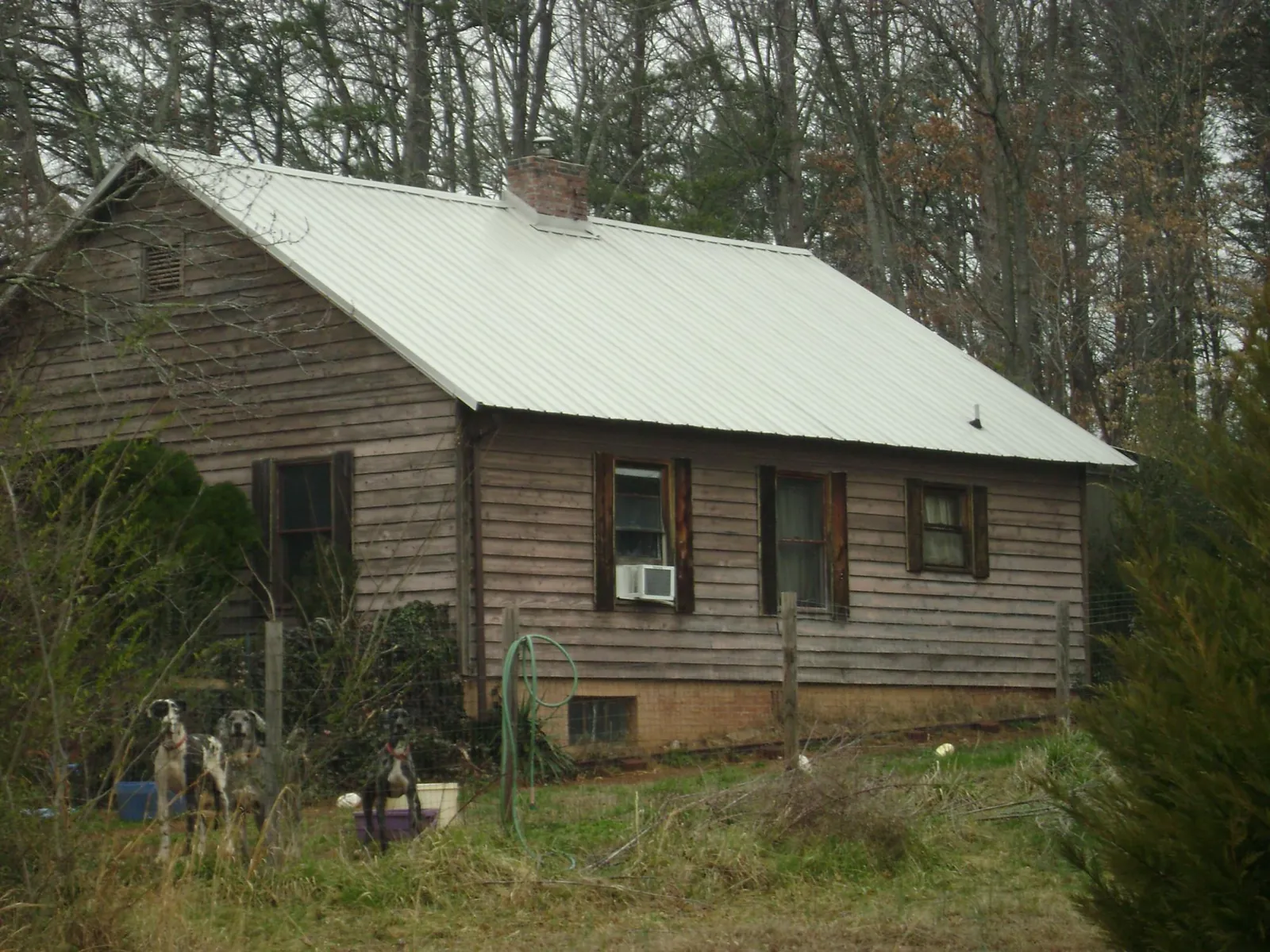 White metal roof on an old wood sided farmhouse, from a Asphalt Shingle Roof Repair job in Calera